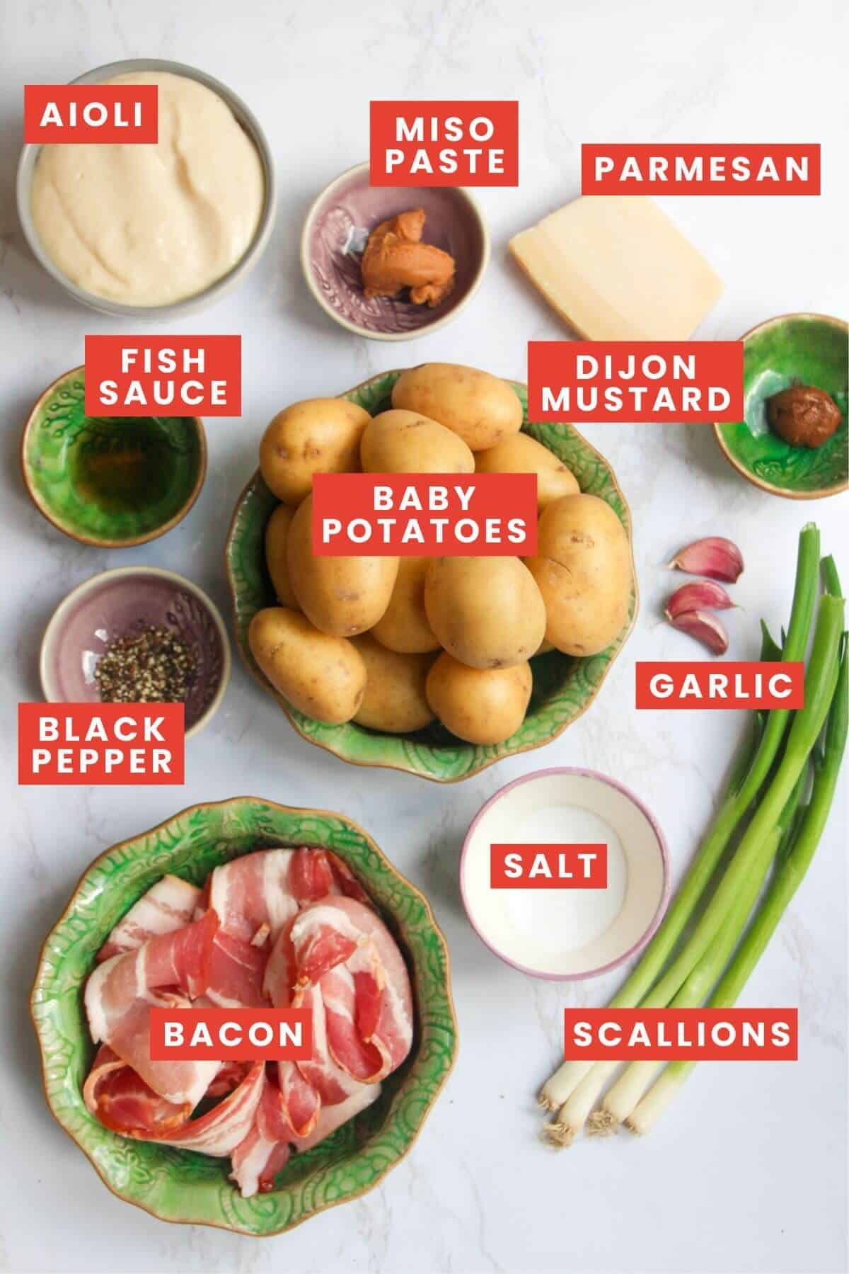 Ingredients for creamy Caesar potato salad laid out on a white marble background.