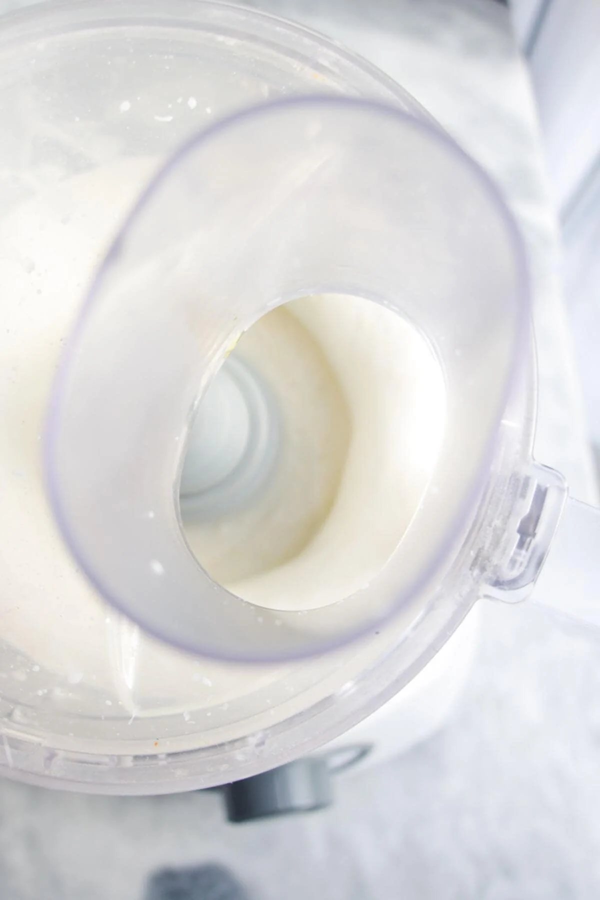 Whipped feta blitzing in the bowl of a food processor.