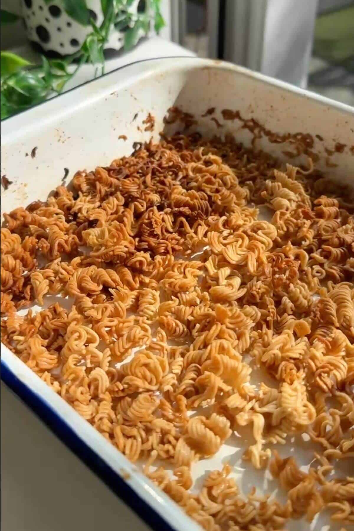 Ramen noodle pieces baked until crispy and golden in a tray.
