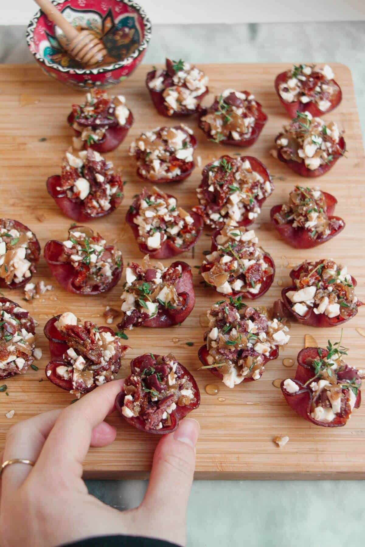Loaded crispy salami bites on a wooden board.