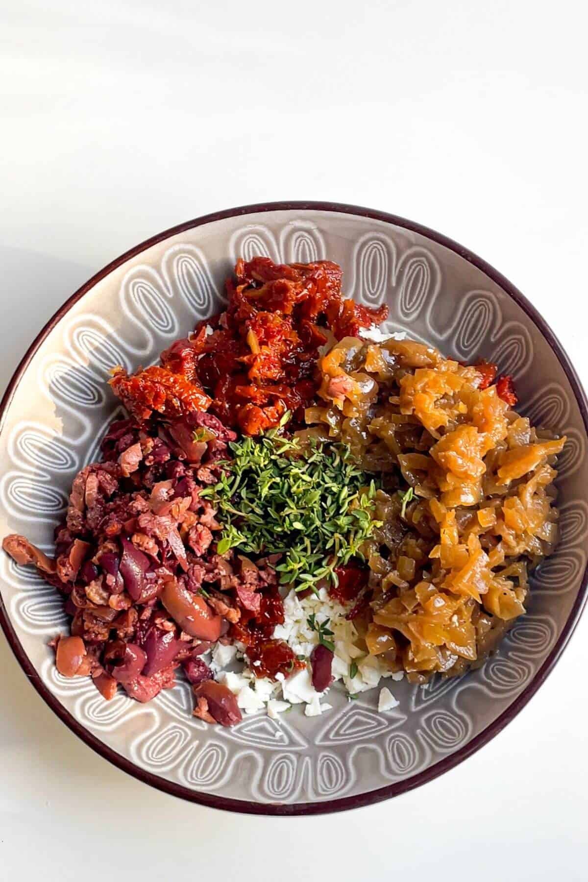 Chopped antipasti ingredients in a grey bowl.