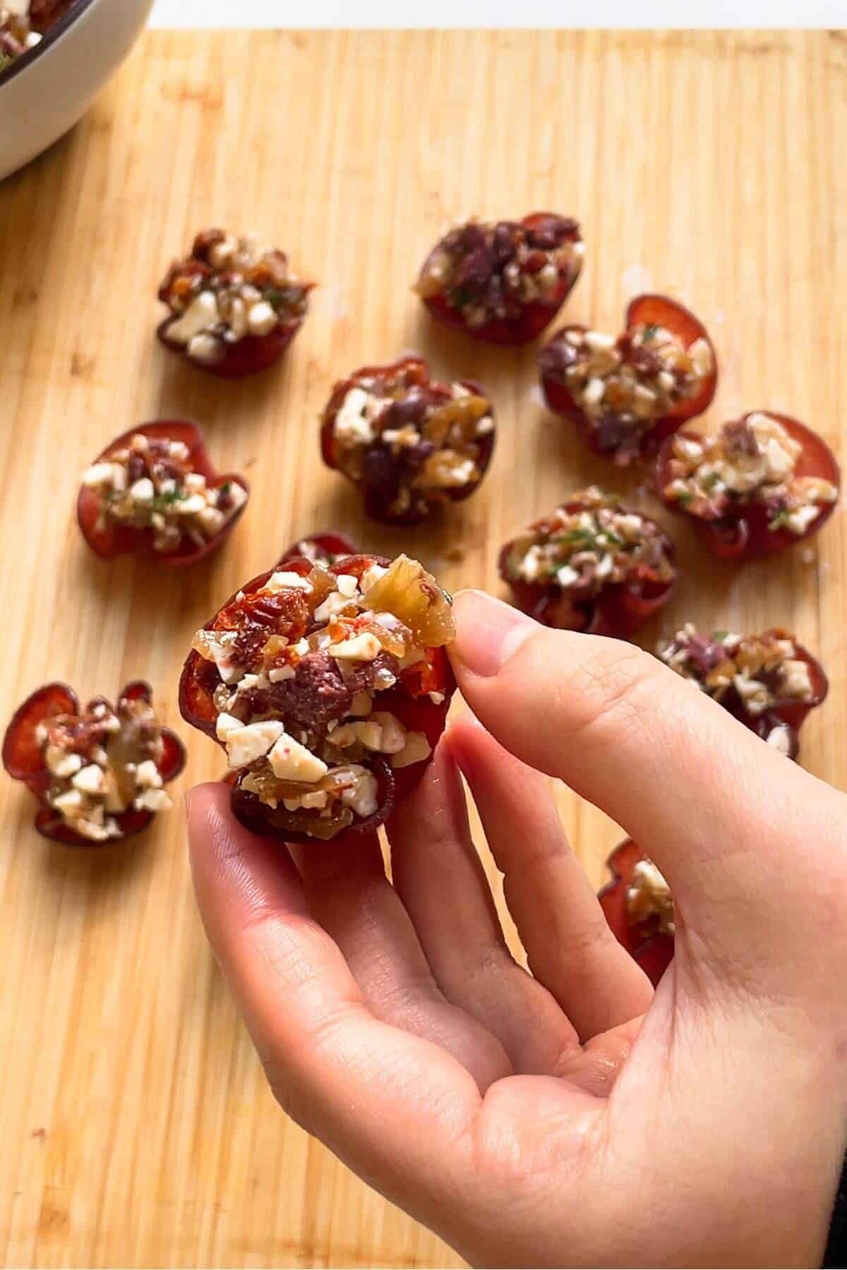 Hand holding a crispy filled salami bite.