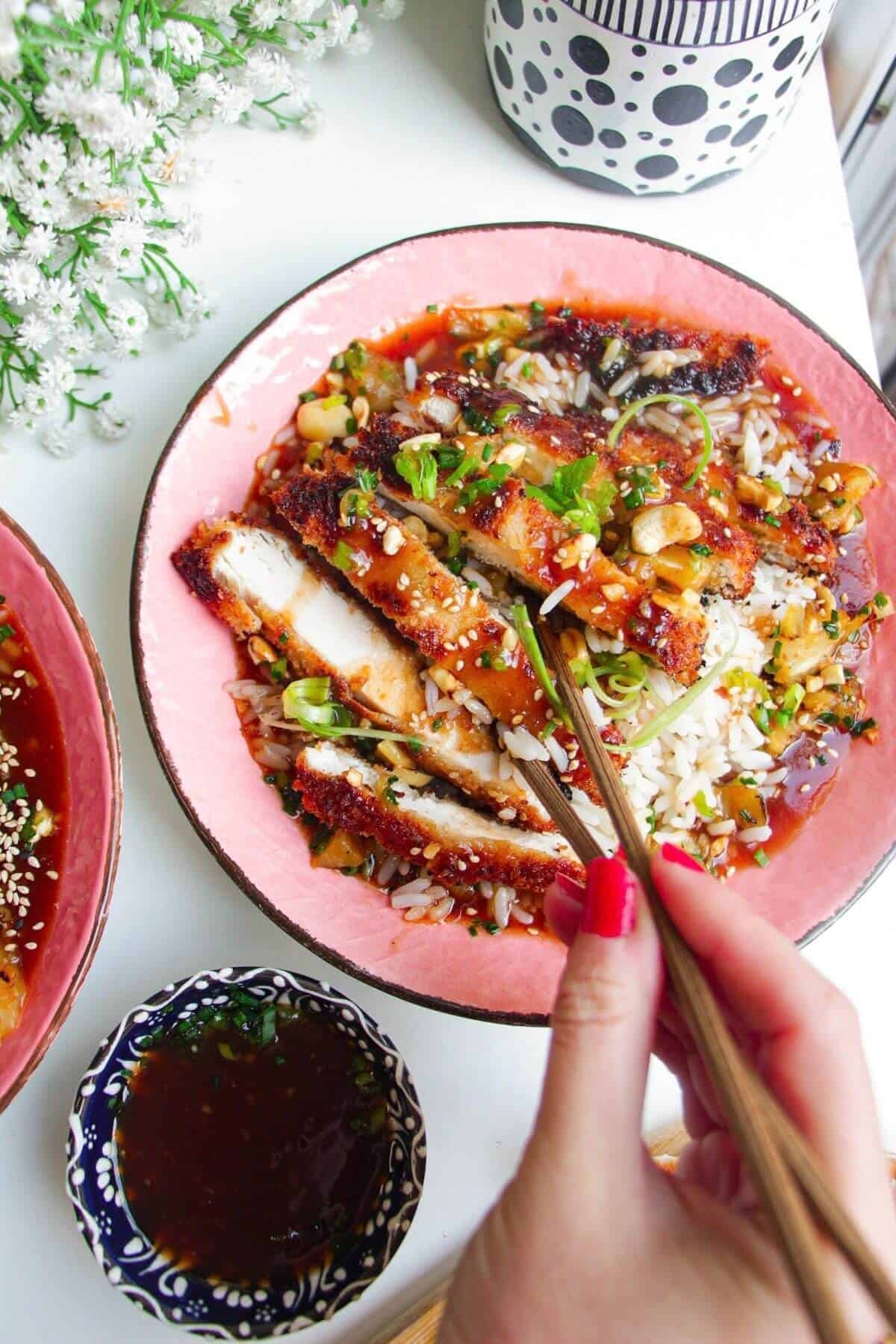 Crispy sweet and sour chicken in a bowl with rice.