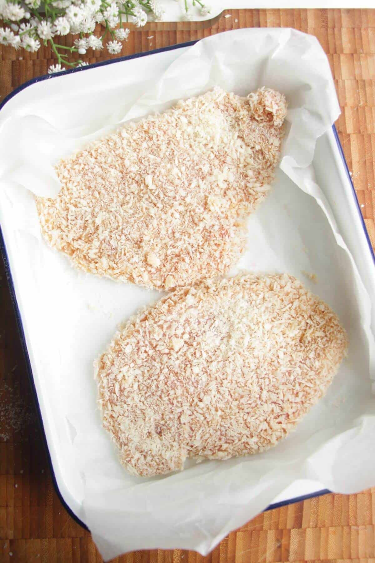 Panko crumbed chicken breasts in a dish.