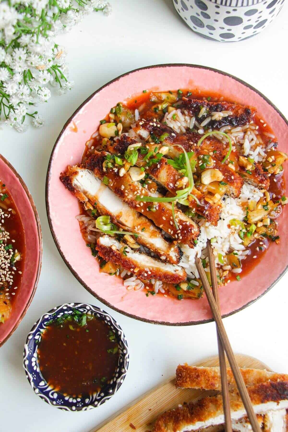 Crispy sweet and sour chicken in a bowl with rice.
