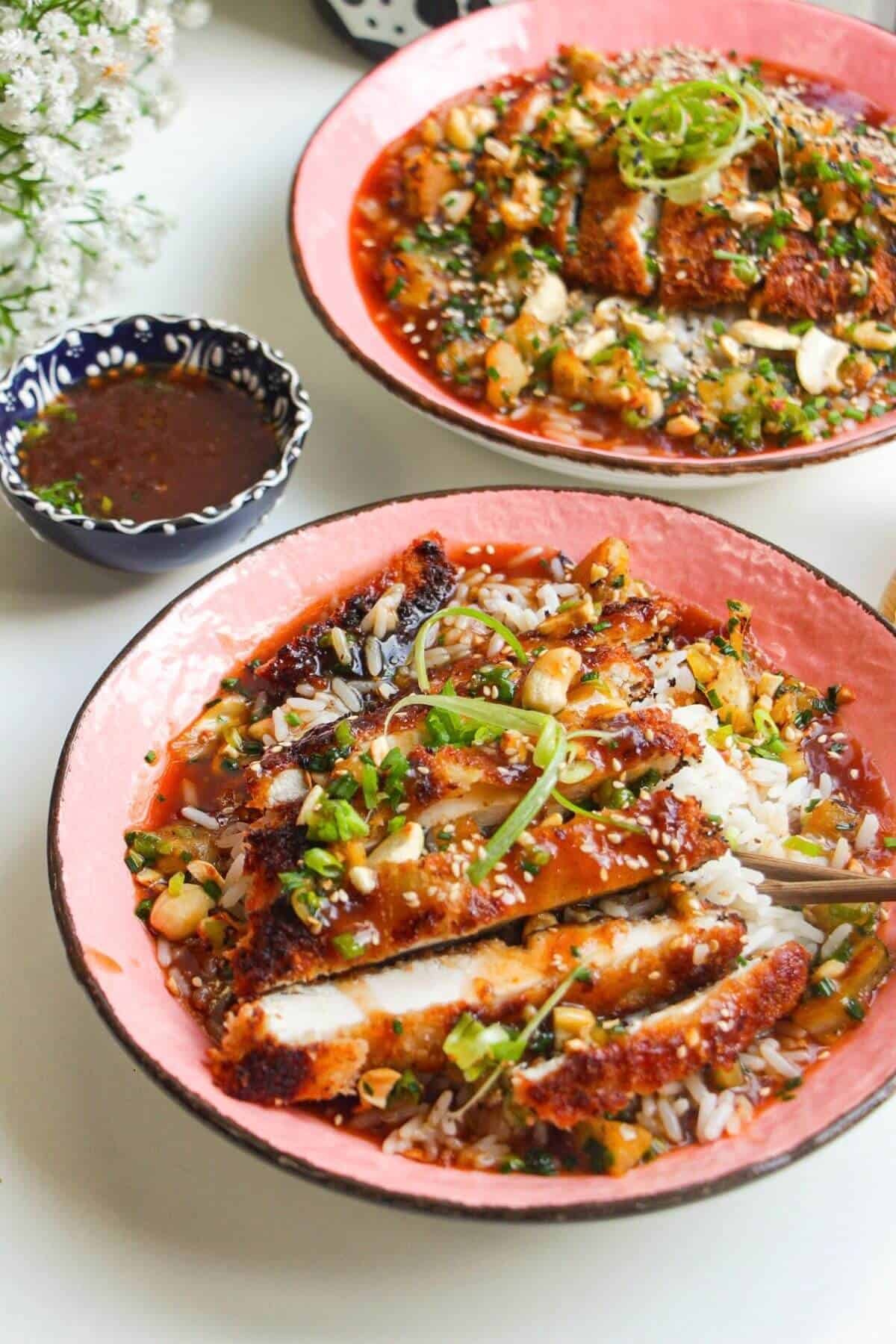 Crispy sweet and sour chicken in a bowl with rice.