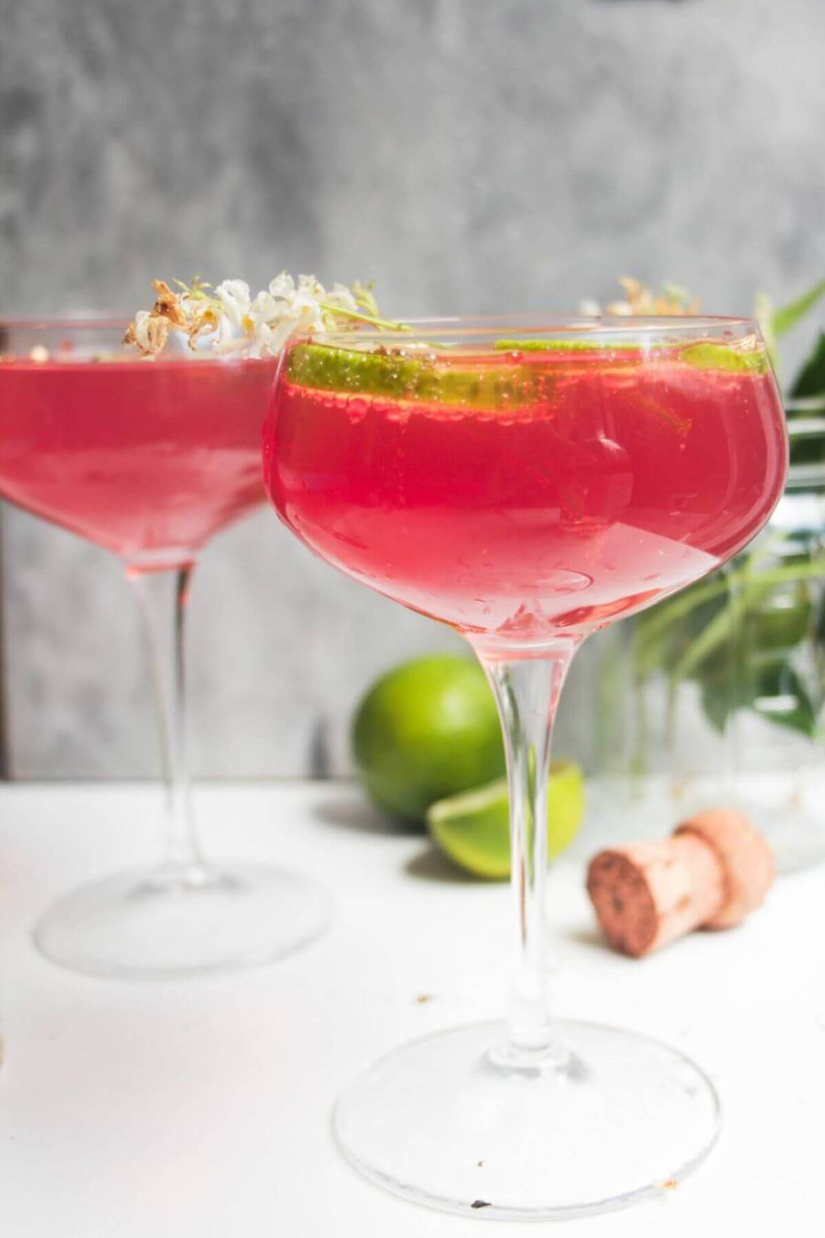 Pink Barbie spritz in a glass coupe, with another glass in the background.