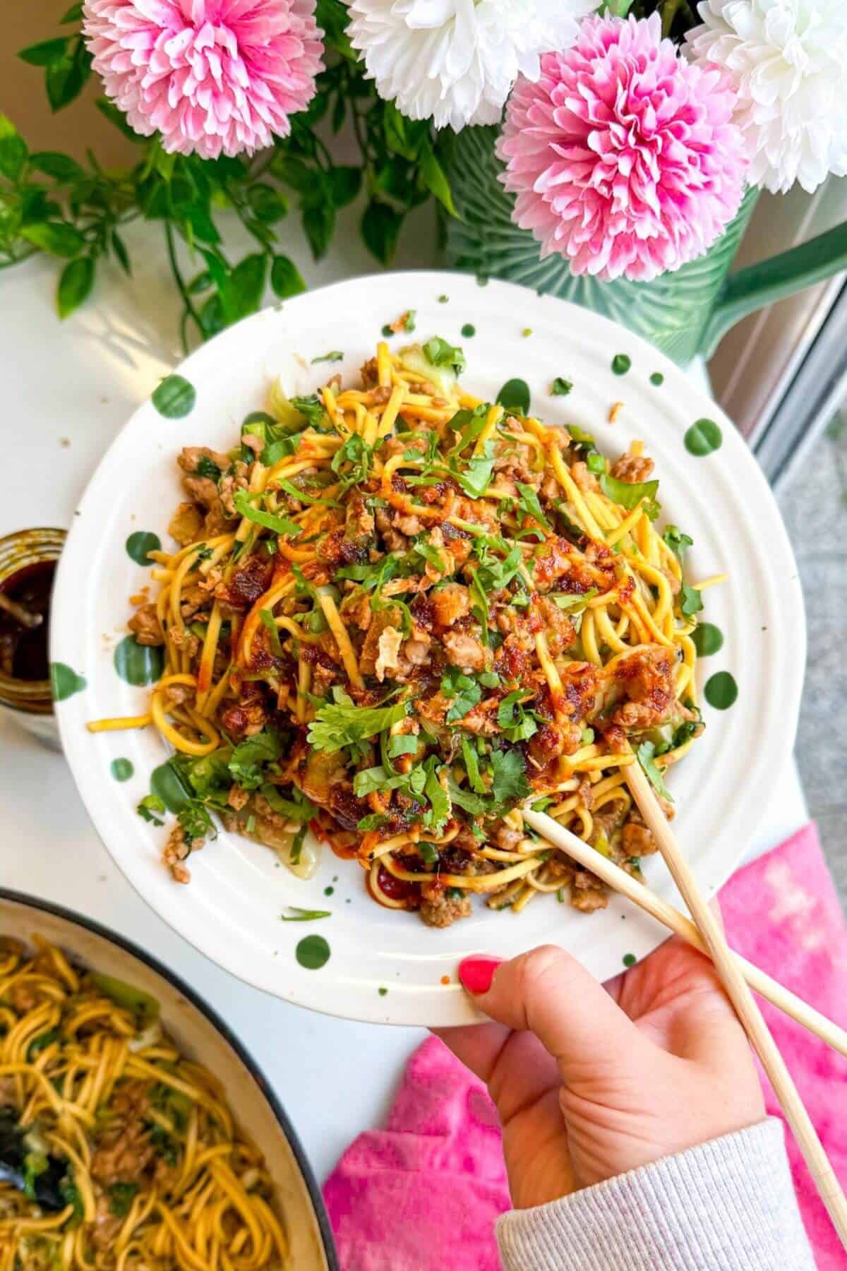 Dumpling noodles on a serving plate with chopsticks.