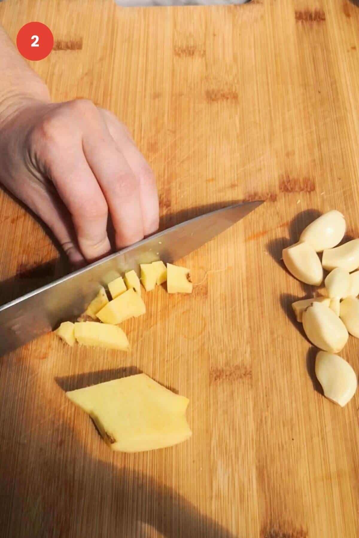 Slicing ginger on a chopping board.