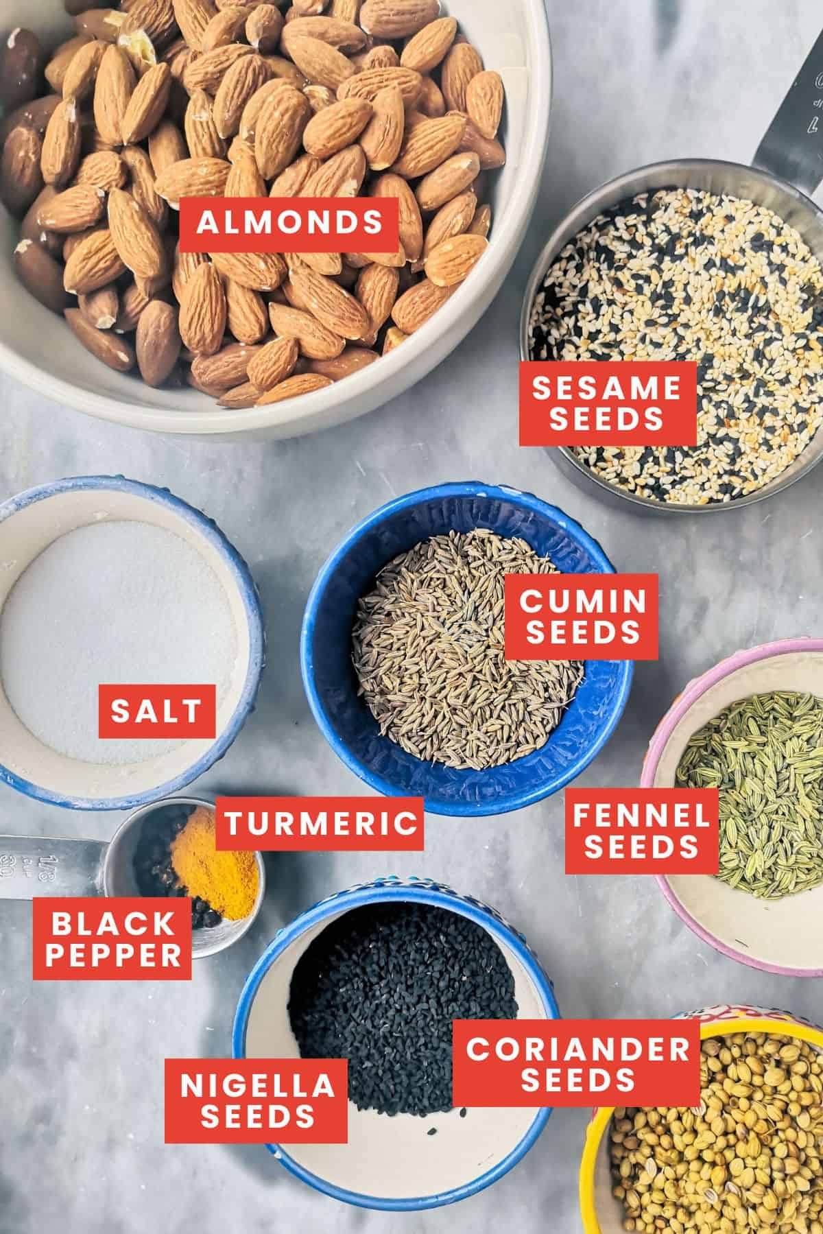 Dukkah ingredients laid out on a grey marble background.
