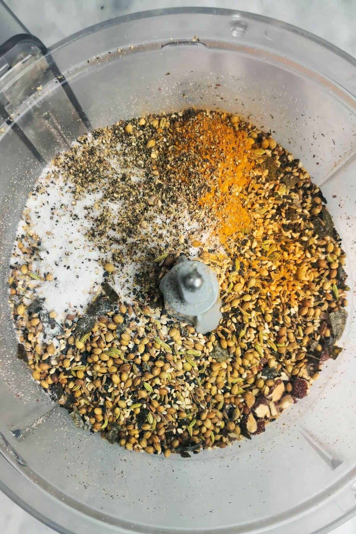 Dukkah ingredients in the bowl of a food processor.