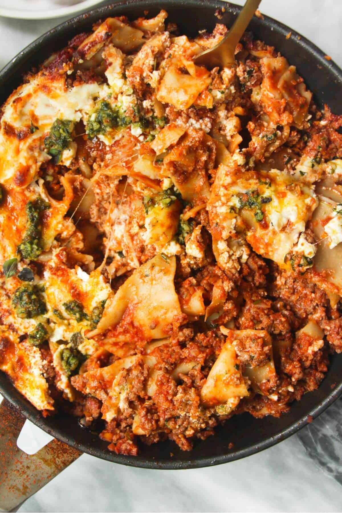 Close up of one pot lasagna in a small black pan.
