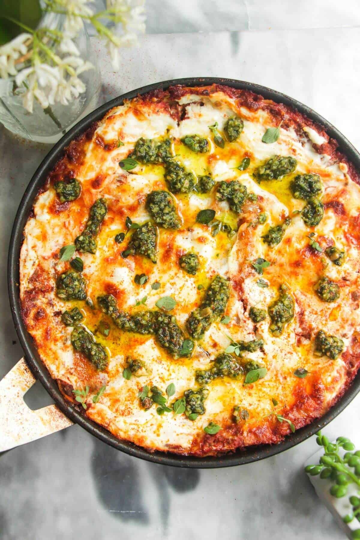 Pesto topped one pot lasagna in a small black pan.
