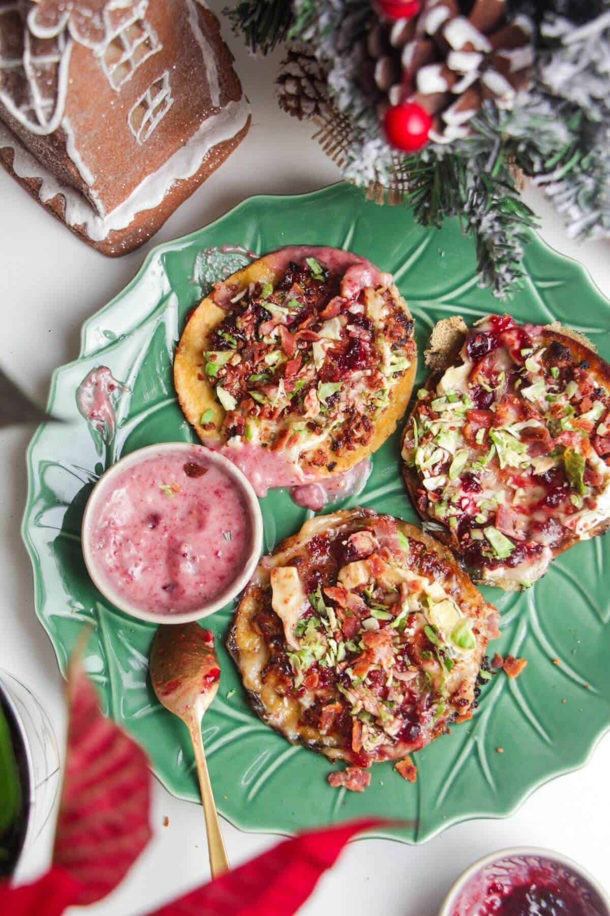 Three smash festive tacos on a green plate.