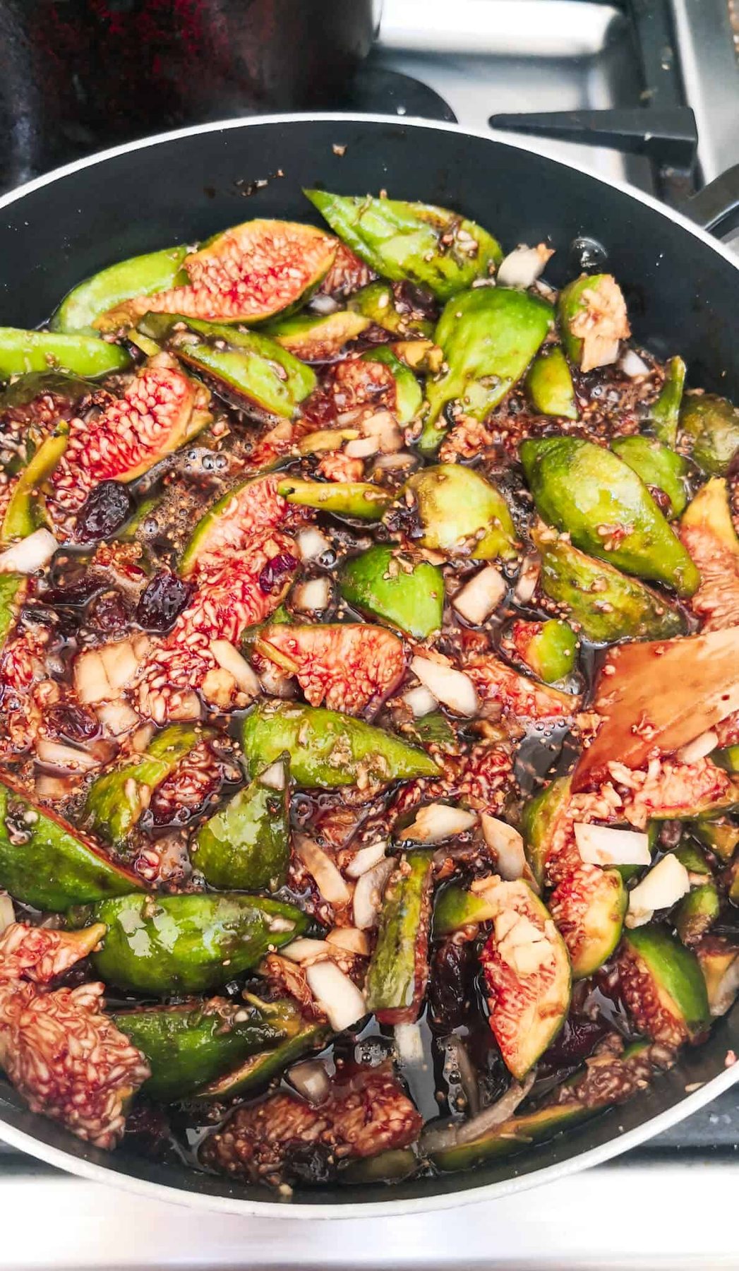 Fig chutney simmering on the stove top in a large pot.