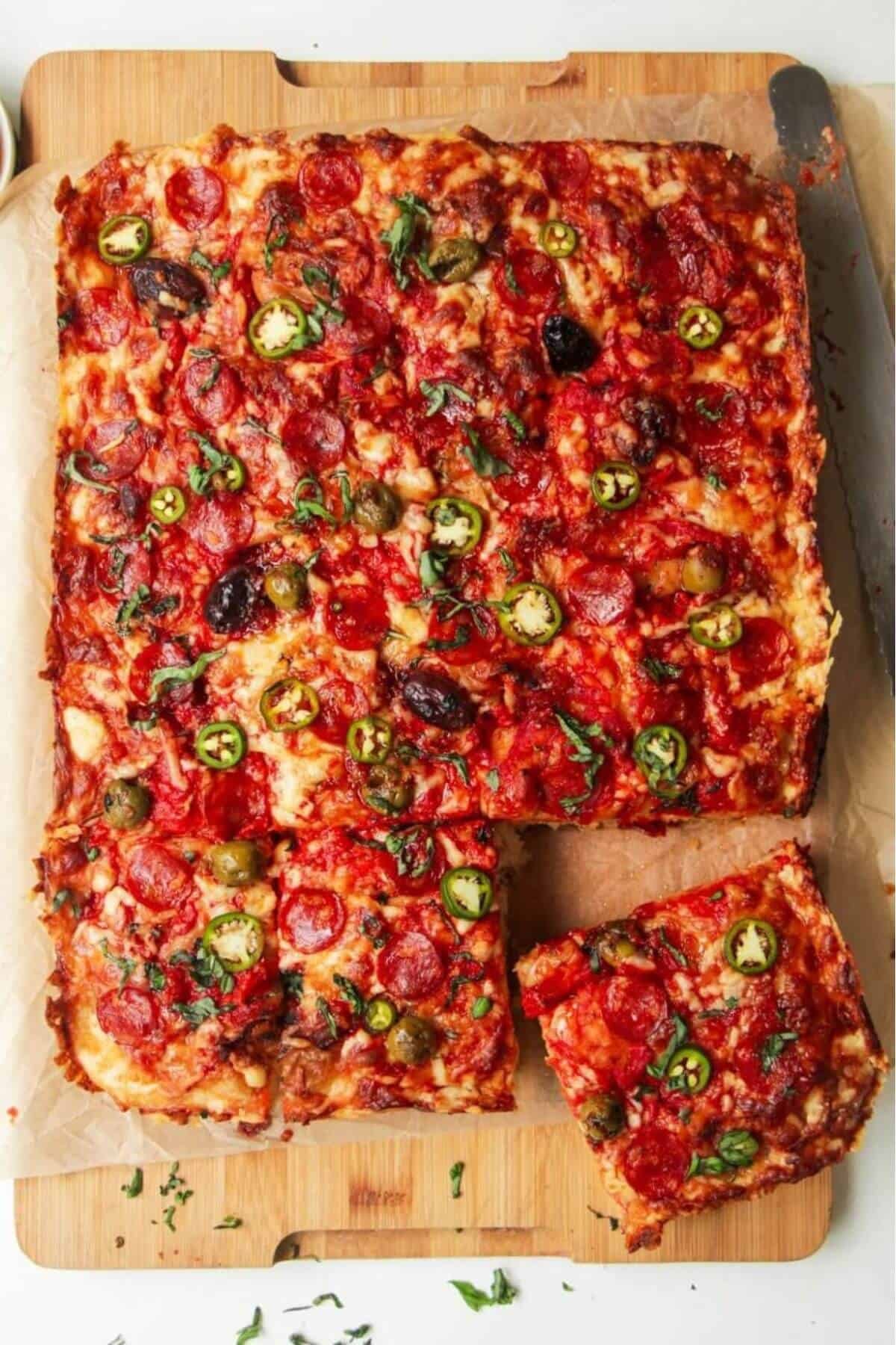 Focaccia pizza bread, sliced on a large wooden board.