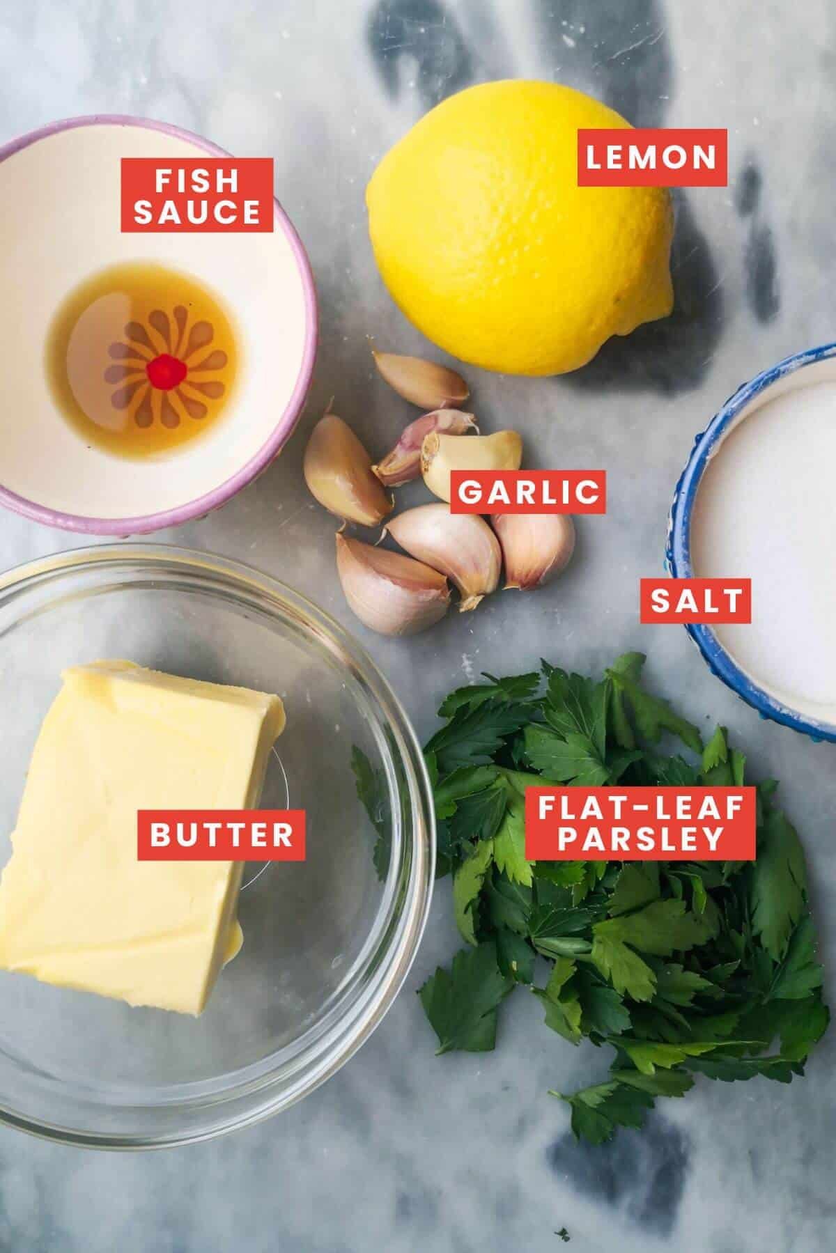 Garlic butter sauce ingredients lying on a grey marble background.