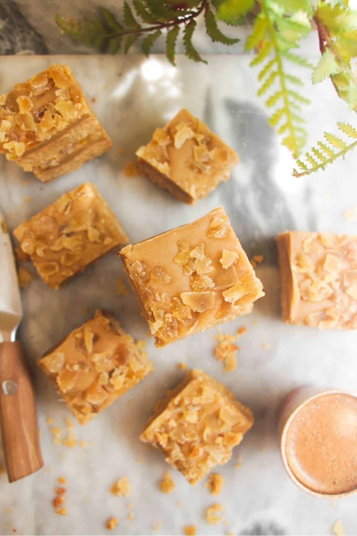 Pile of ginger crunch on top of each other with a coffee cup on the side.