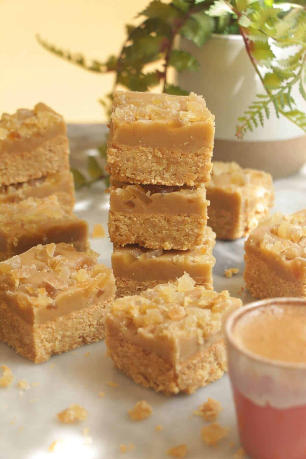 Pile of ginger crunch on top of each other with a coffee cup on the side.
