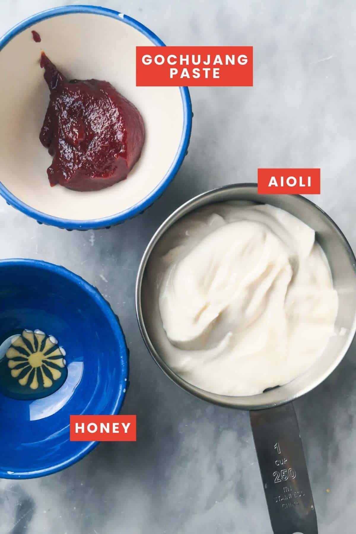 Ingredients for gochujang mayo laid out on a grey marble background and labelled.