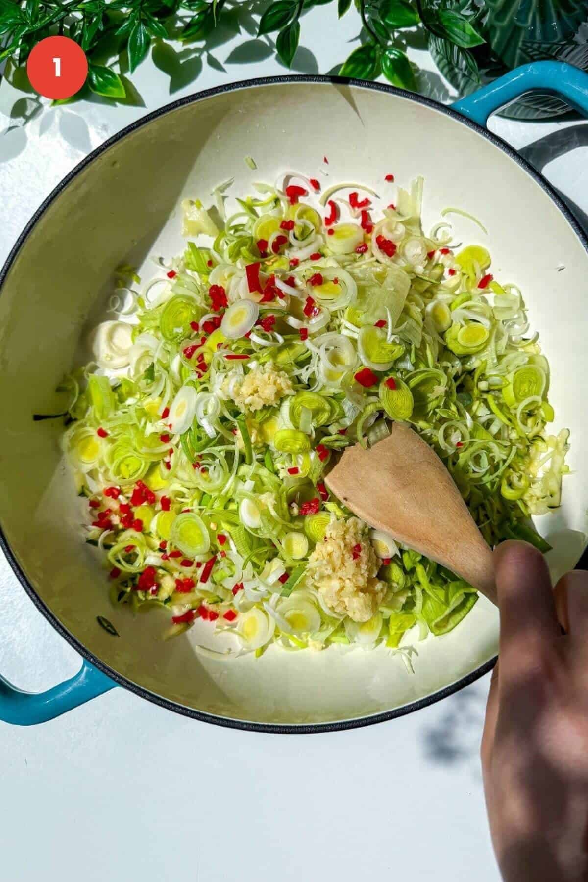 Leeks, zucchini and chili added to a skillet.