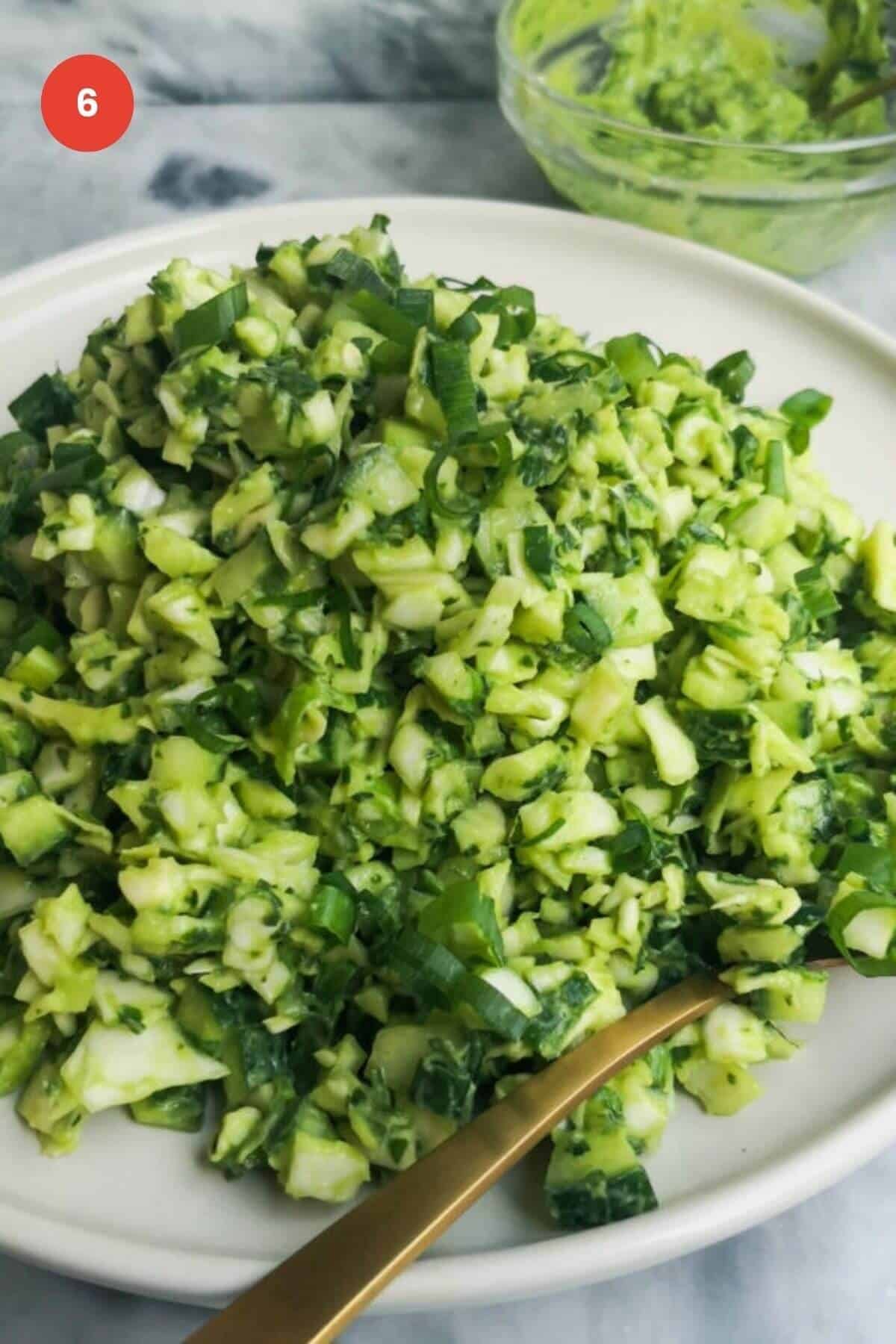 Green goddess salad on a plate with serving spoon.