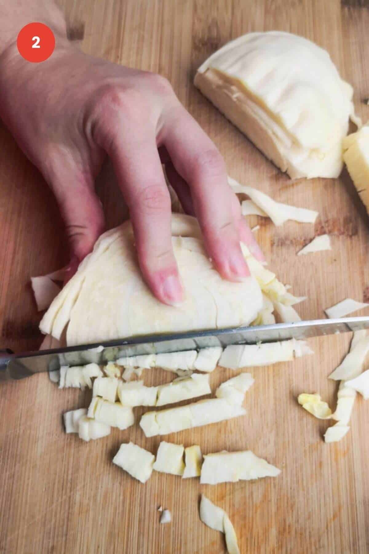 Slicing white cabbage on a wooden board.