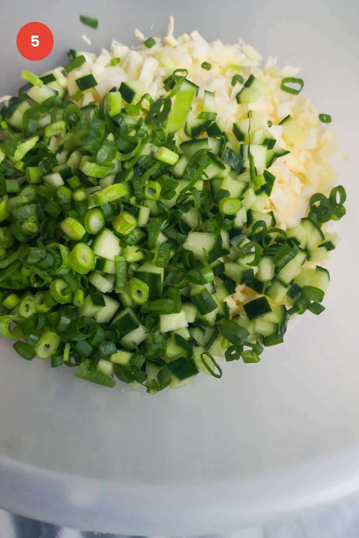 Green goddess salad ingredients in a mixing bowl.