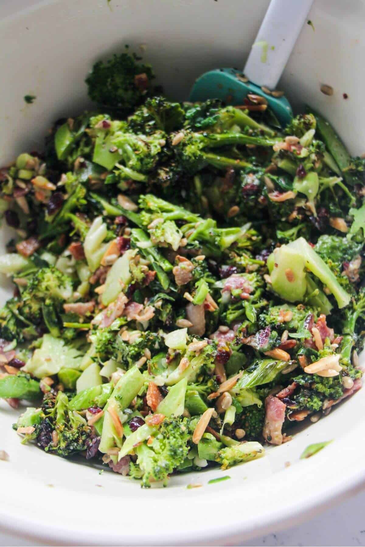 Grilled broccoli salad mixed in a large white bowl.