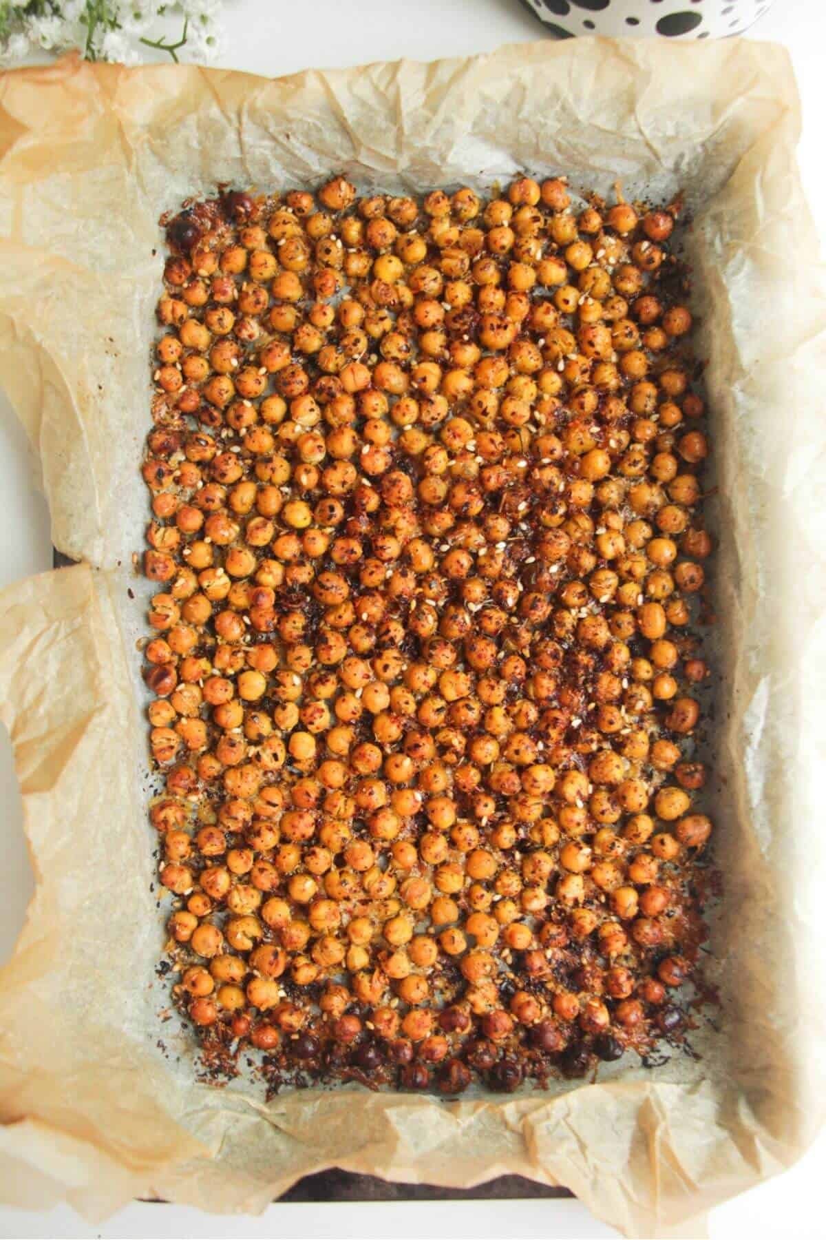 Crispy chickpeas in a baking paper lined tray.