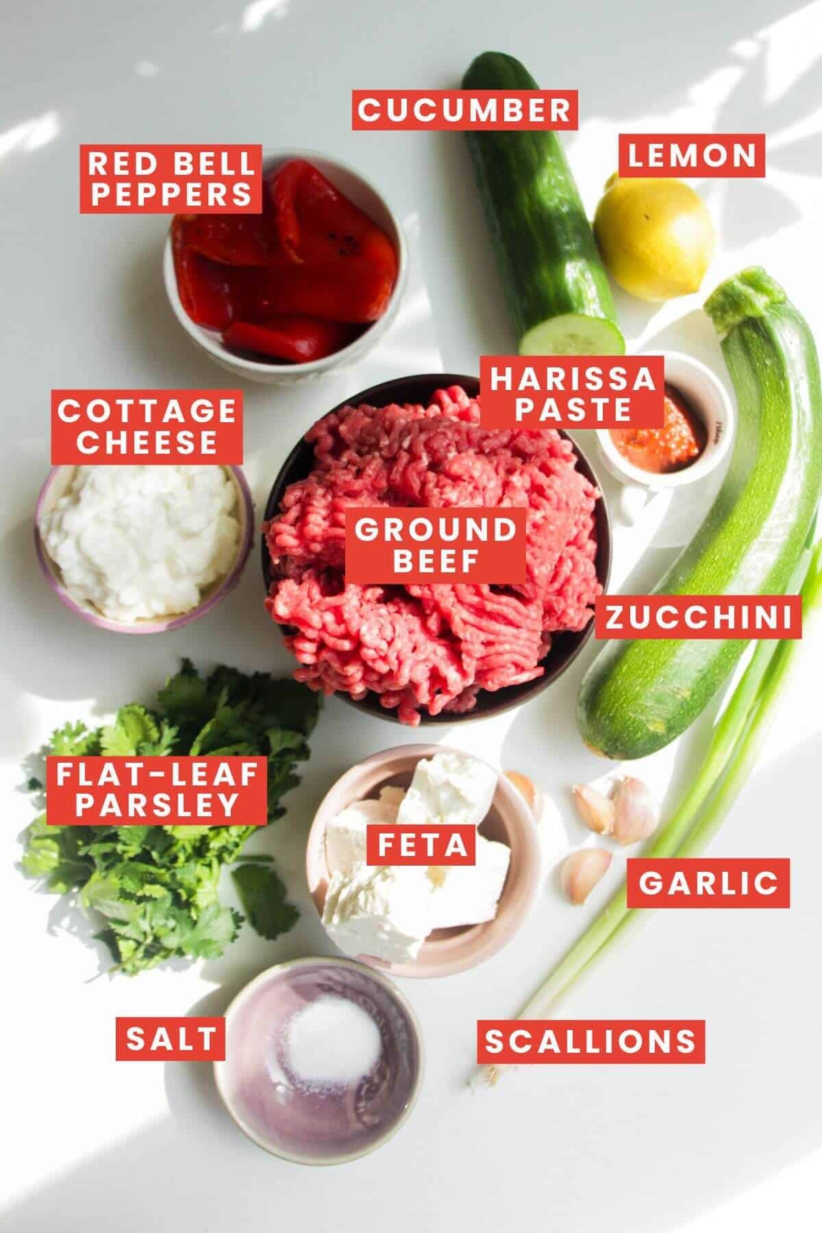 Ingredients for harissa, feta & zucchini meatballs laid out and labelled.