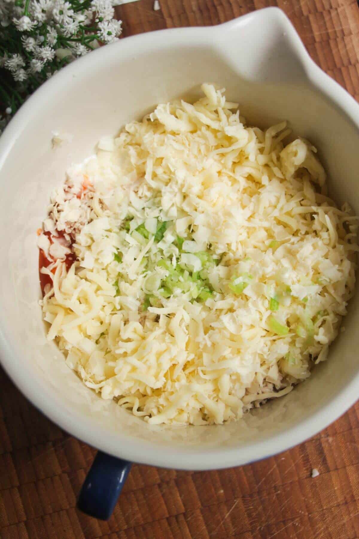 Ingredients for Buffalo chicken dip in a mixing bowl.