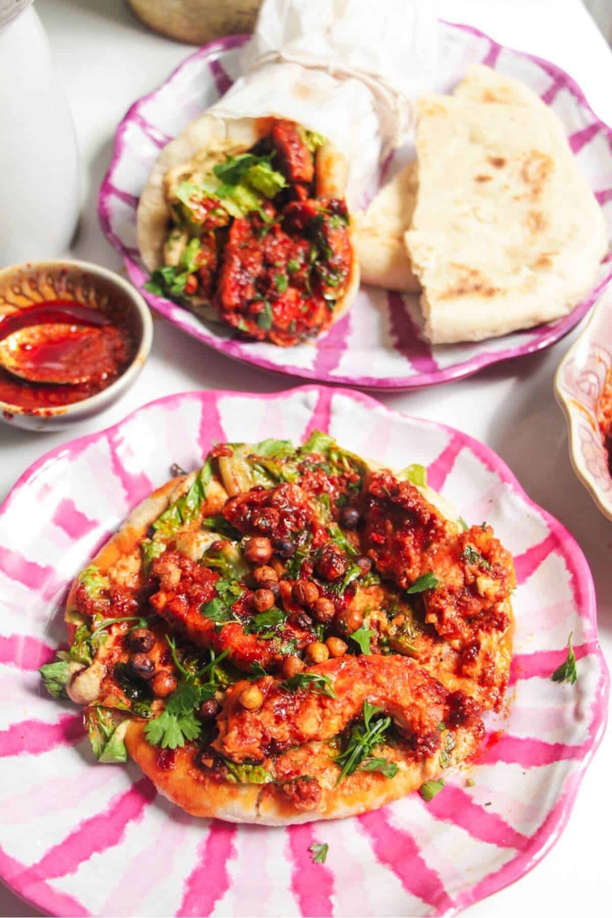 Two flatbreads with honey harissa halloumi, hummus and chickpeas on top.
