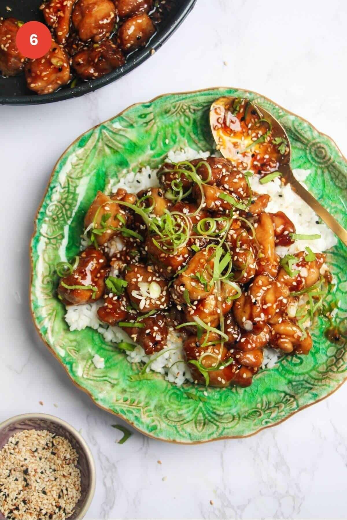 Honey sesame chicken served over rice on a plate.