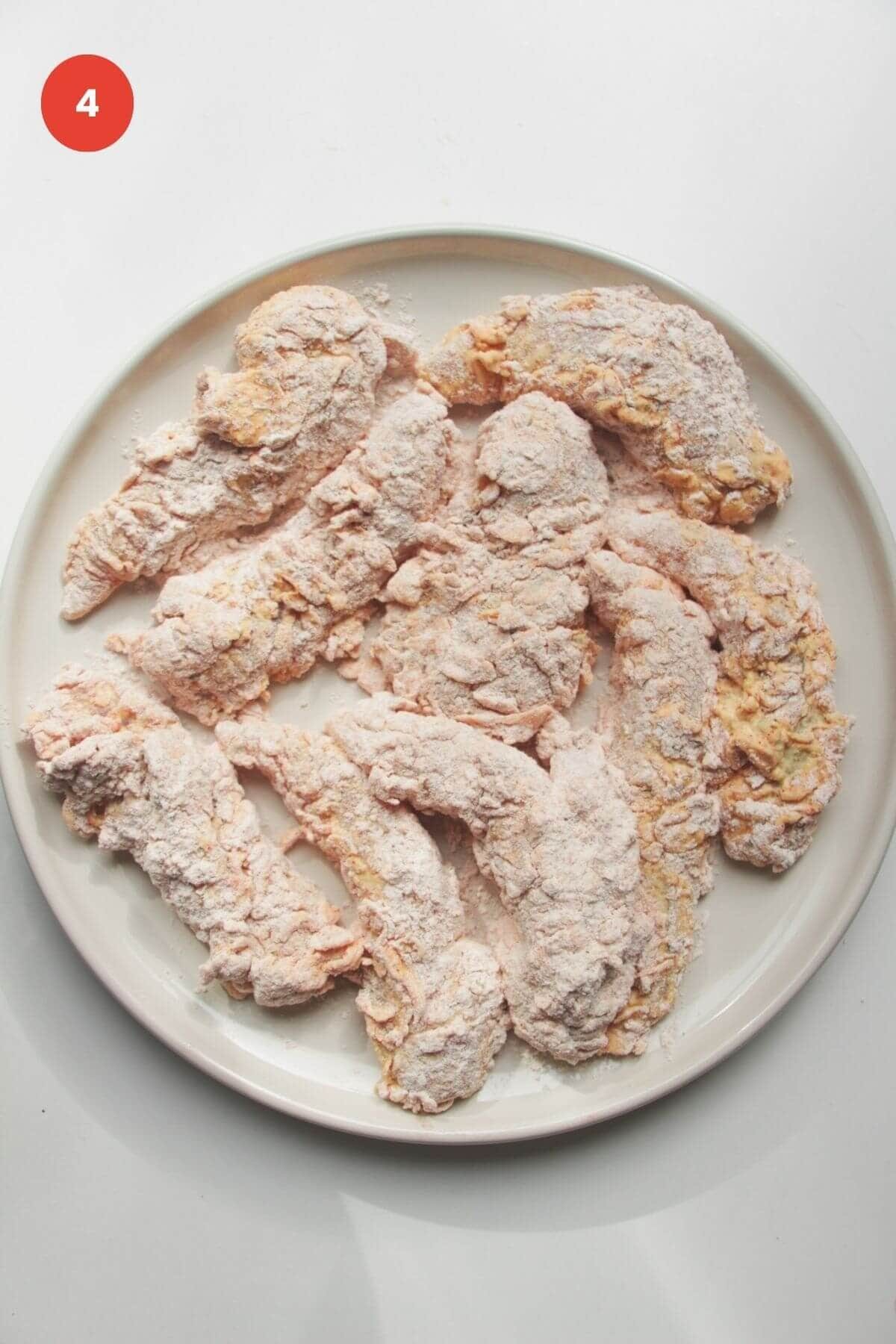 Coated chicken tenders on a plate.