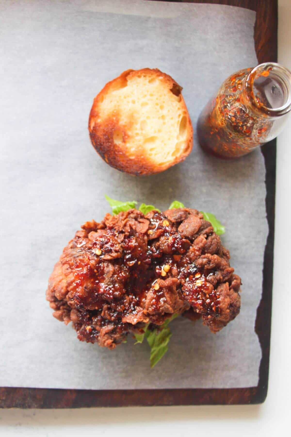 Fried chicken on a burger bun, with hot honey drizzled on top.