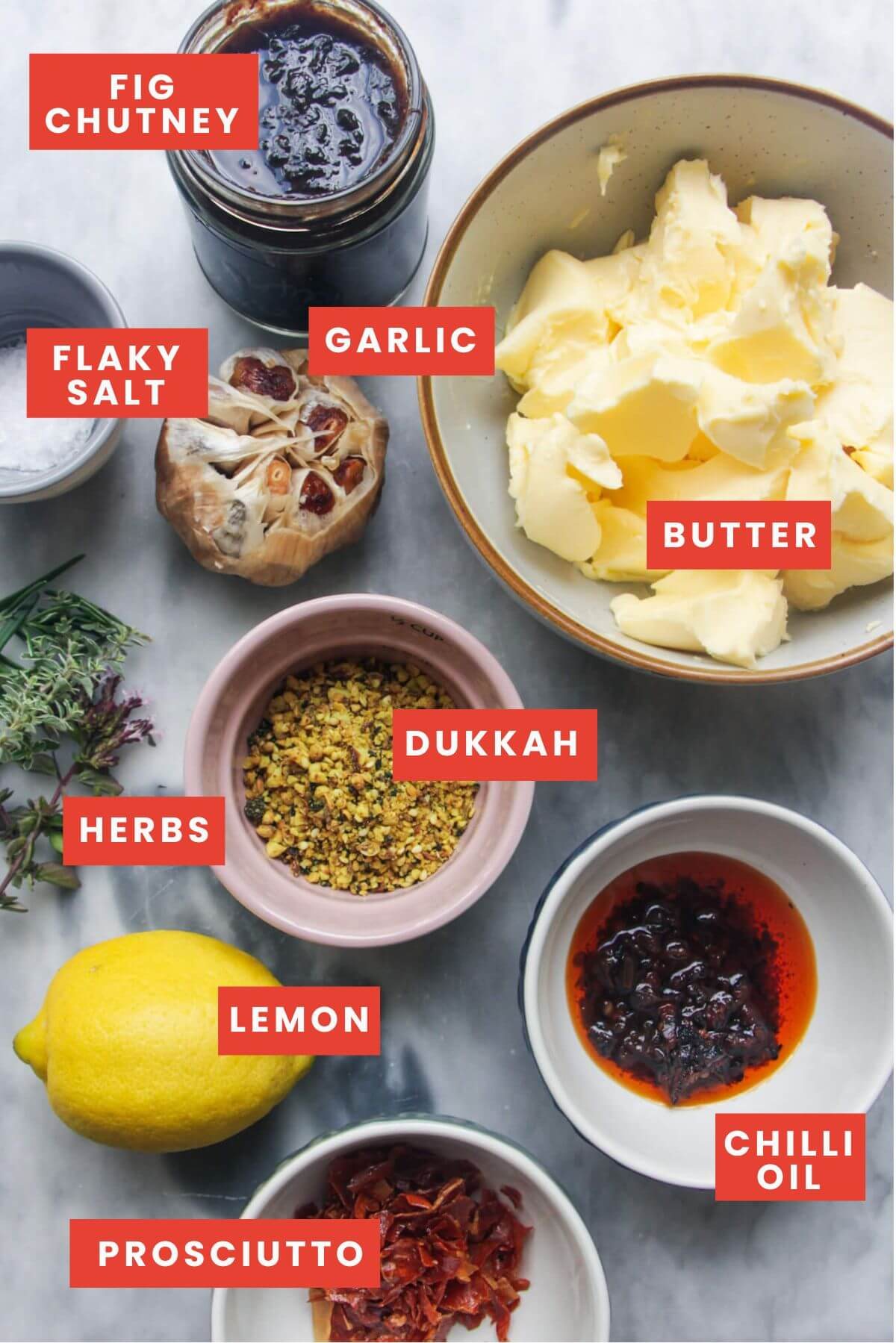 Butter board ingredients laid out on a marble background, labelled.