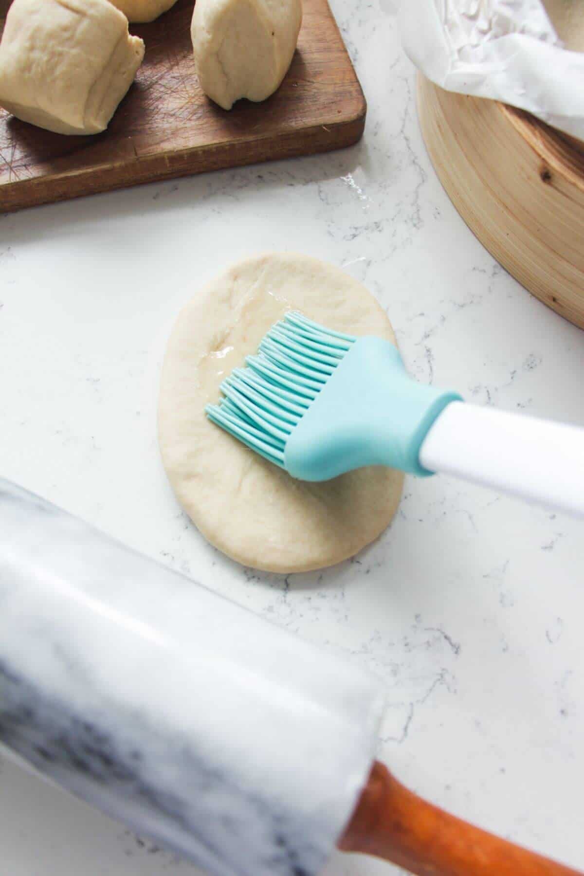 Brushing bao with oil.