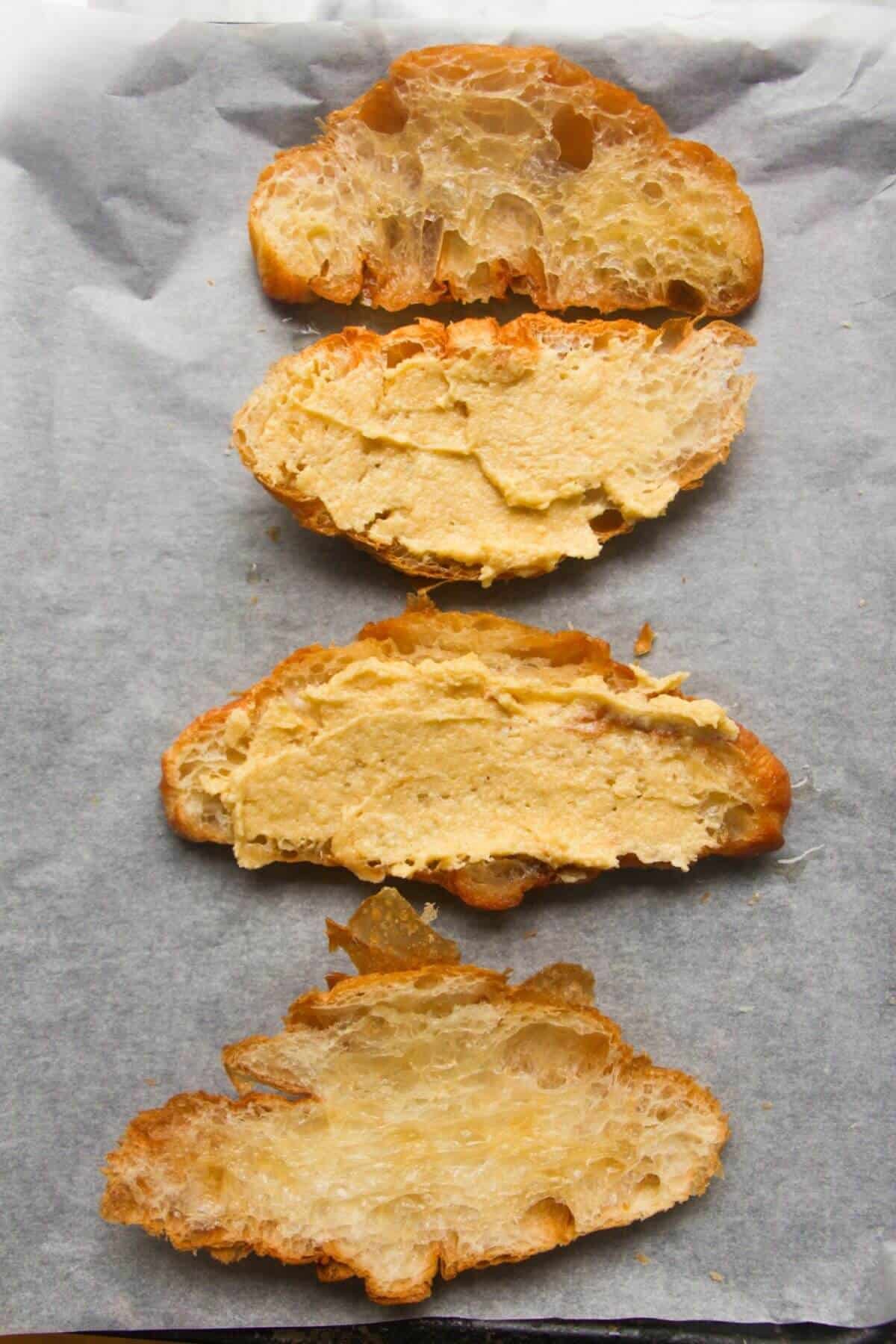 4 croissant halves with frangipane on them.