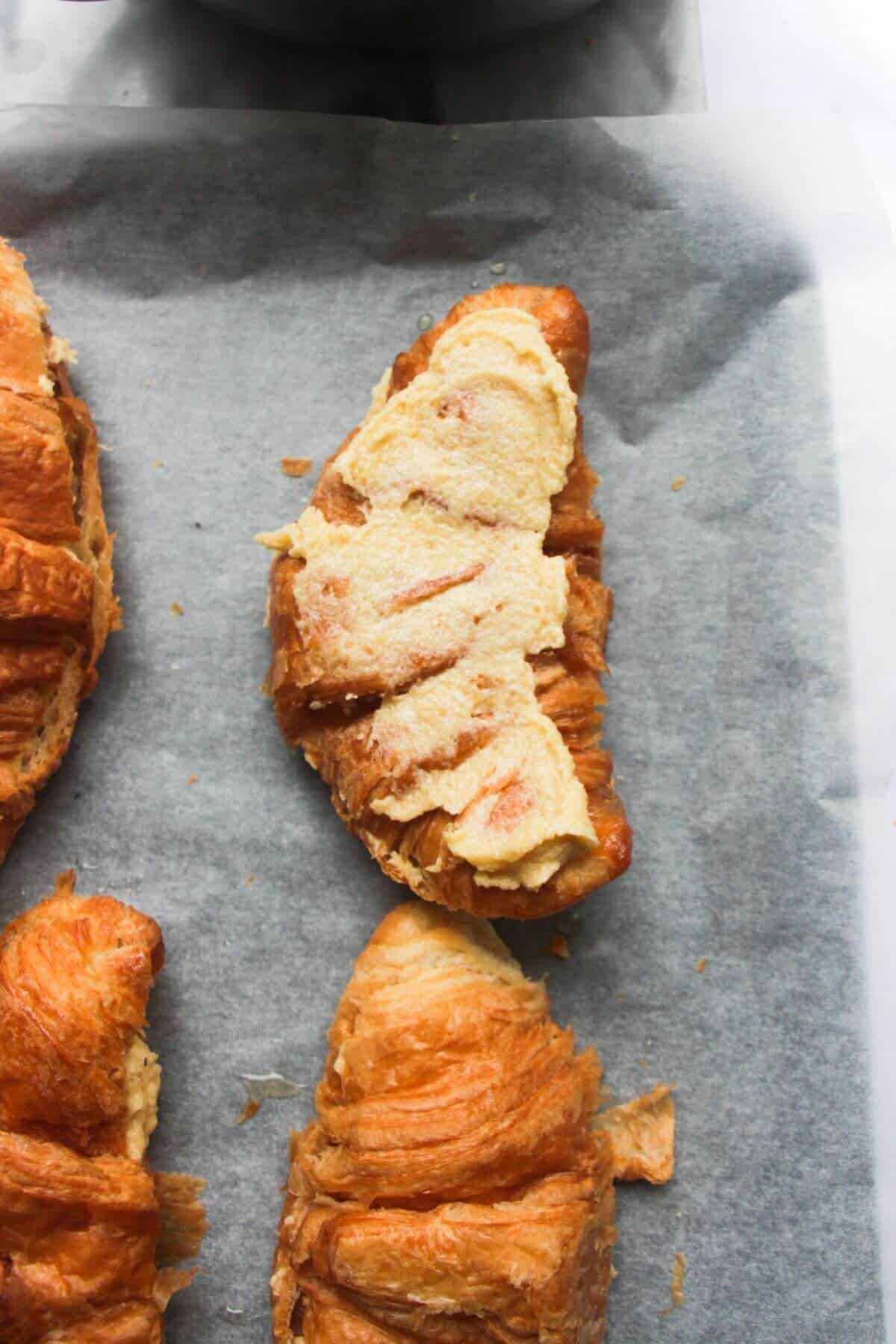 Close up of a frangipane topped croissant ready for flaked almonds.