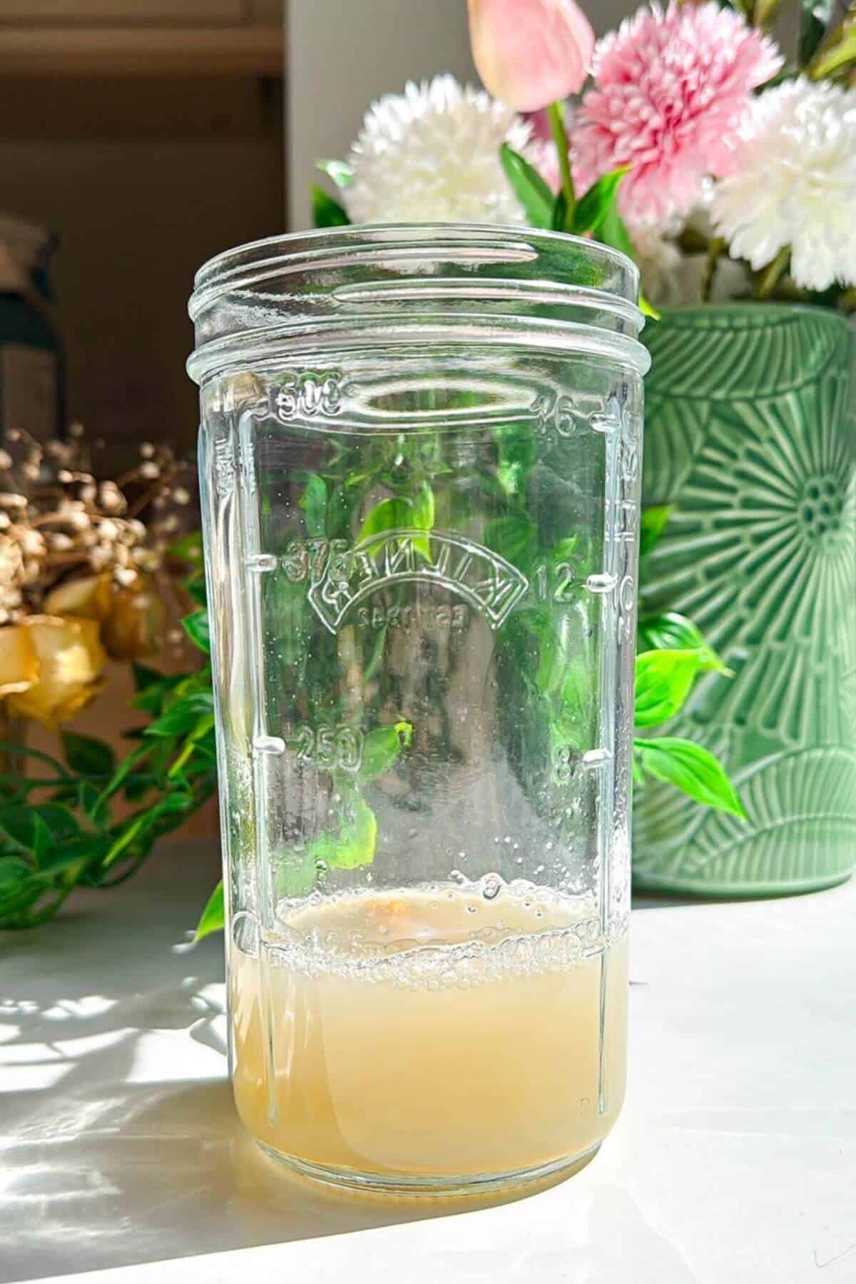 Aqufaba and other ingredients in a tall glass jar.