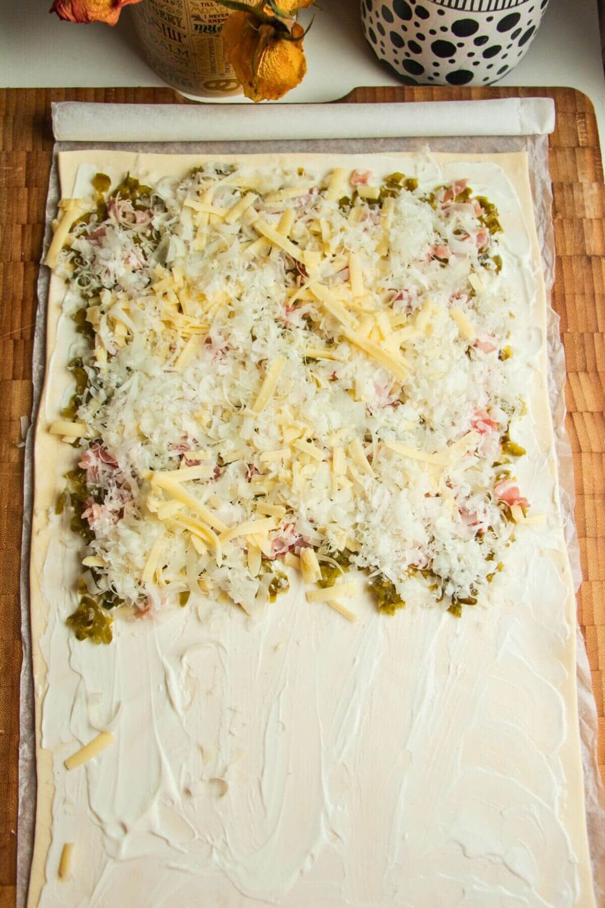 Grated cheese on top of chopped jalapenos and bacon.