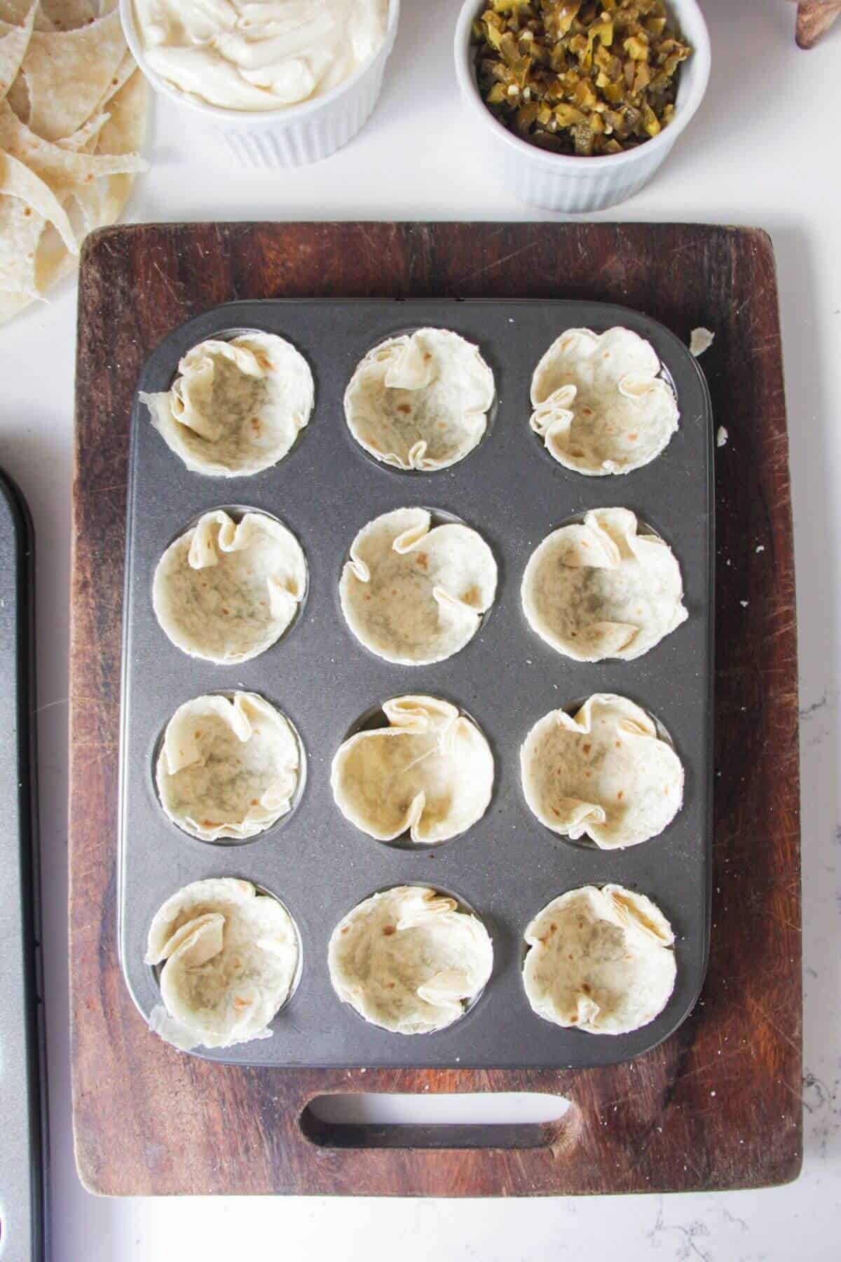Mini tortillas pressed in a mini muffin tin.