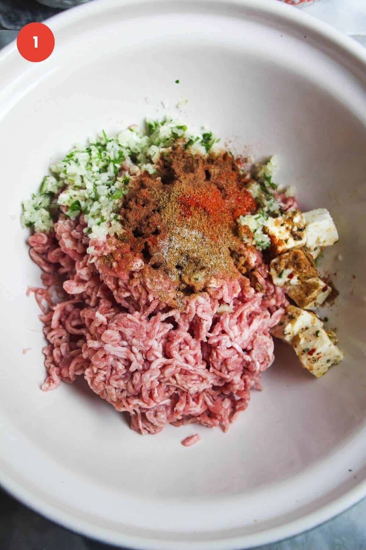 Ground lamb with spices in a large mixing bowl.