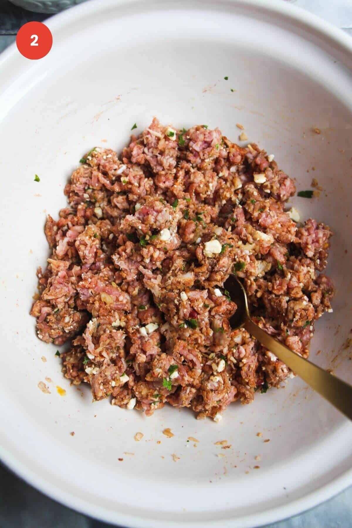 Ground lamb mixed with spices in a mixing bowl.