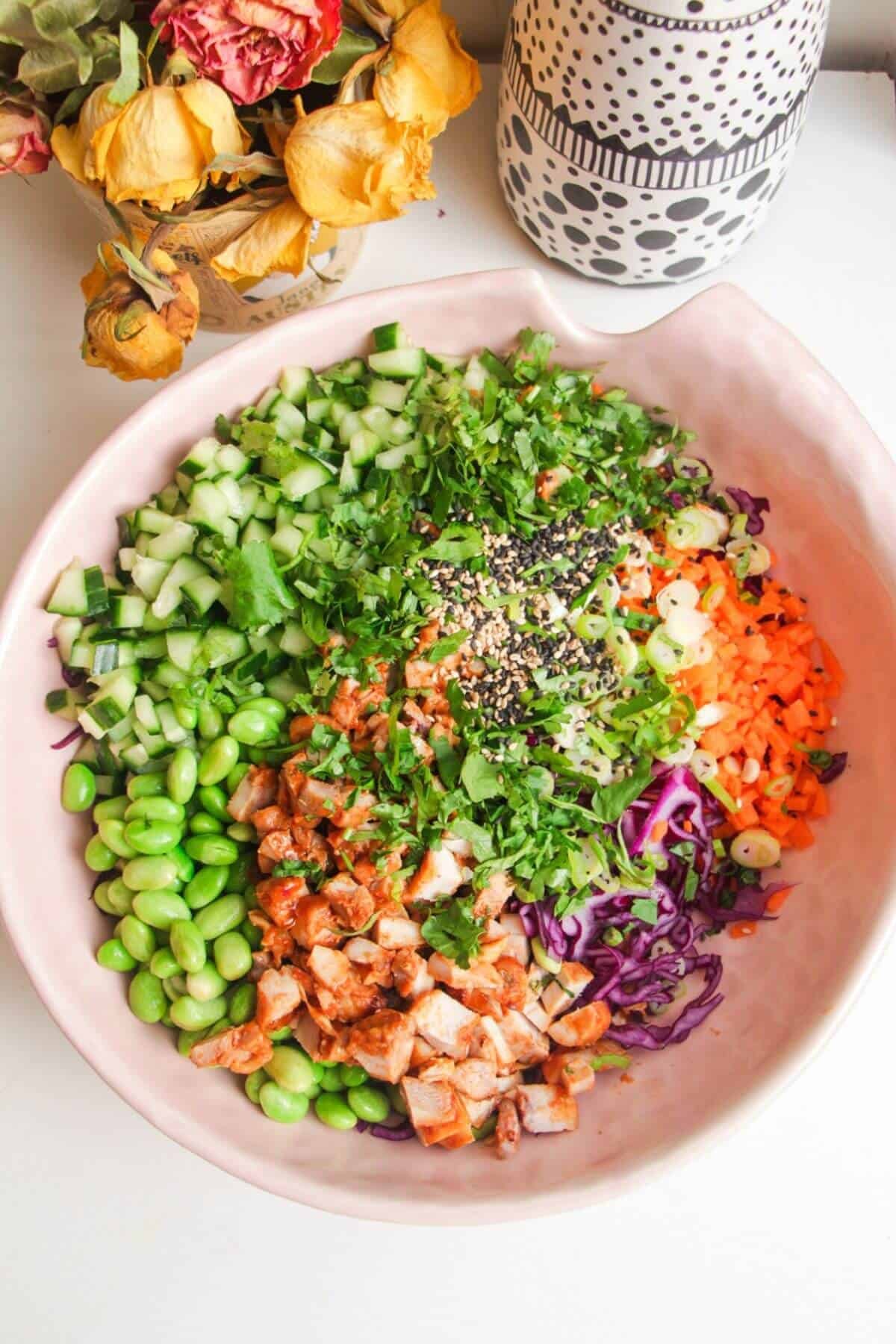 Ingredients for Korean chicken salad in a large pink bowl.
