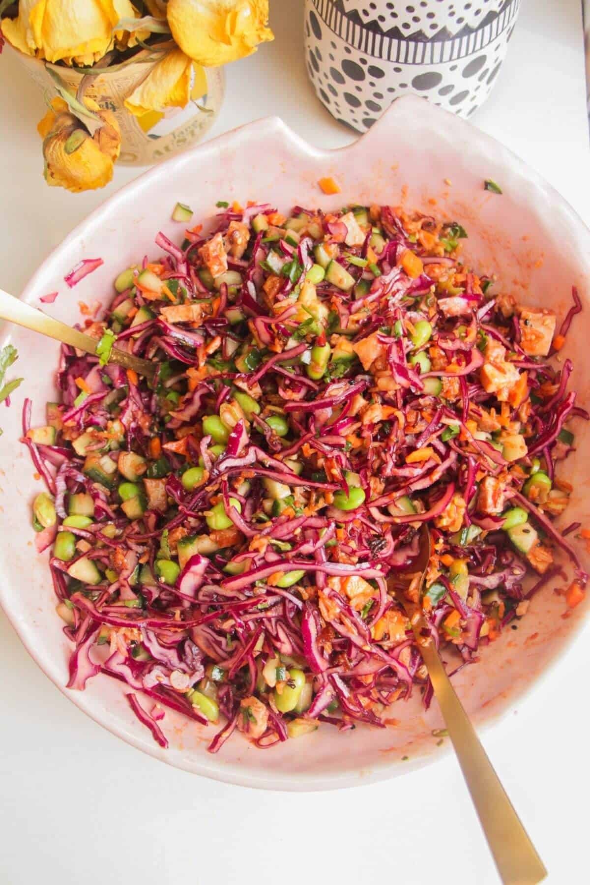 Korean chicken salad mixed in a large pink bowl.