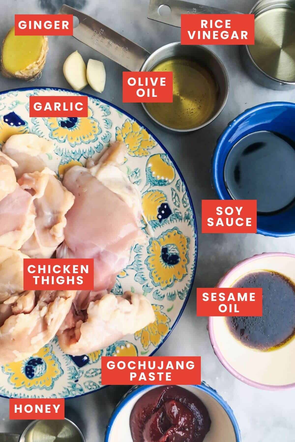 Ingredients for gochujang chicken laid out on a grey marble background.