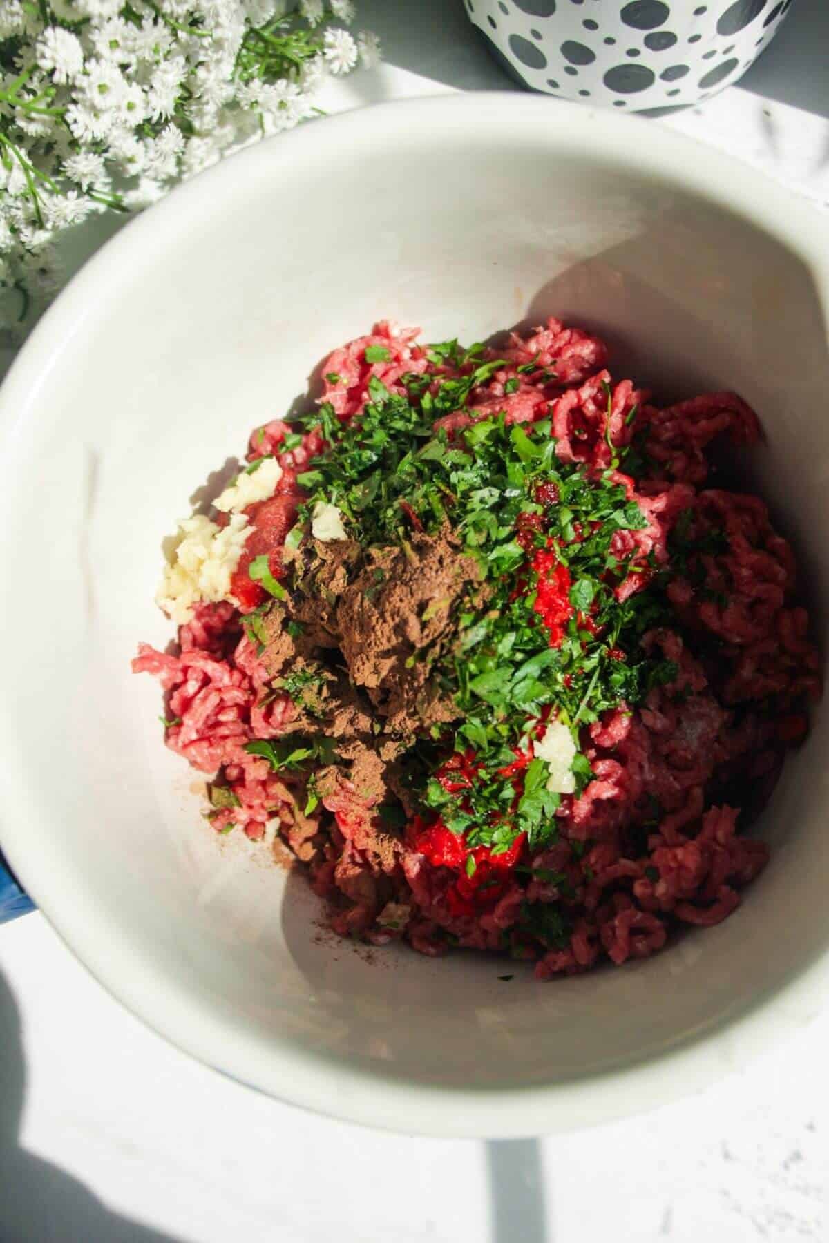 Ground meat and seasoning in a large mixing bowl.
