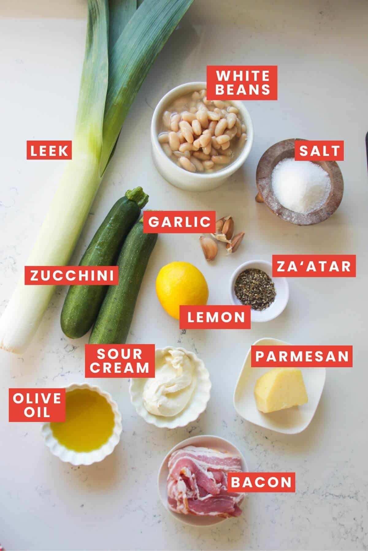 Ingredients for creamy leek and zucchini beans laif out and labelled.